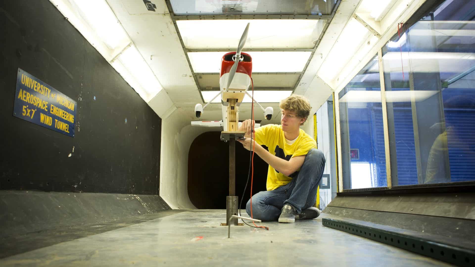 male student adjusts a plane that he is testing